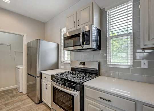 A kitchen with a stove top oven and a refrigerator. at Habitat @ DTLV, Las Vegas, 89106