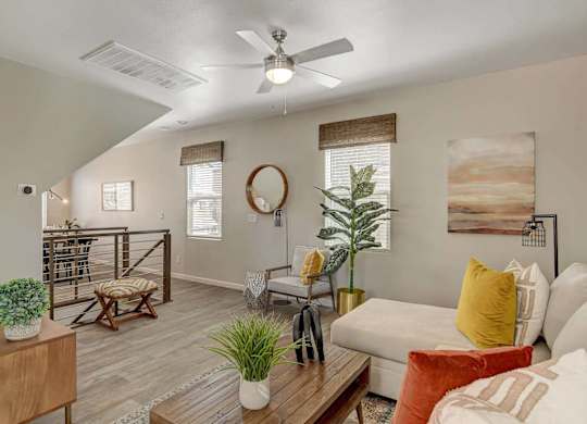 A living room with a white couch, a wooden coffee table, and a ceiling fan. at Habitat @ DTLV, Las Vegas, NV