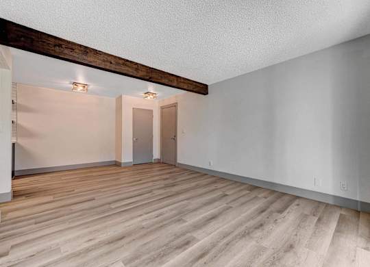 A room with wooden flooring and white walls.