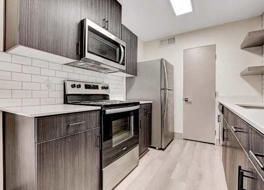 A modern kitchen with a stove top oven and microwave above it.