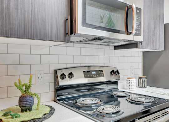 A modern kitchen with a stove top oven and a microwave above it.