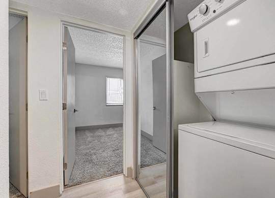 A white washing machine is in a small laundry room.