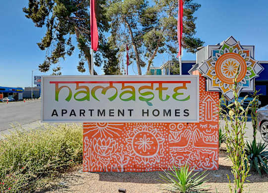 A sign for Bacaste Apartment Homes is displayed in front of a building.