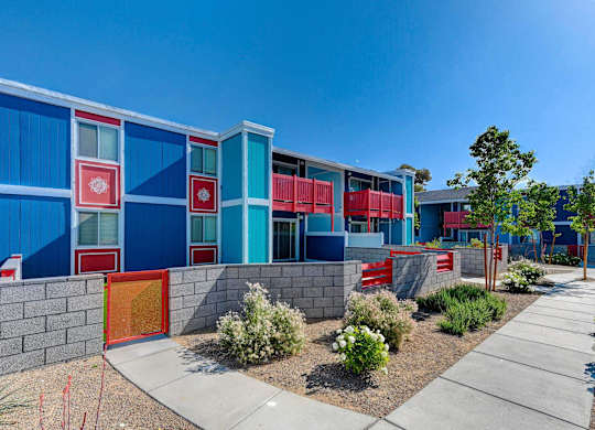 A modern building with blue and red panels and a red door.