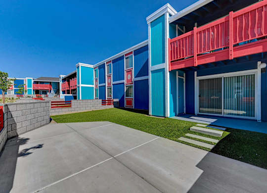 A blue and red building with a white door and windows.