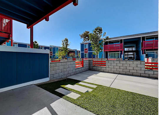 A blue building with a red awning and a white sign with a red border.