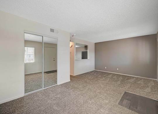A room with a carpeted floor and a sliding glass door.