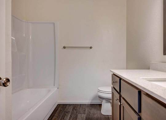 A white bathroom with a toilet, sink, and shower.