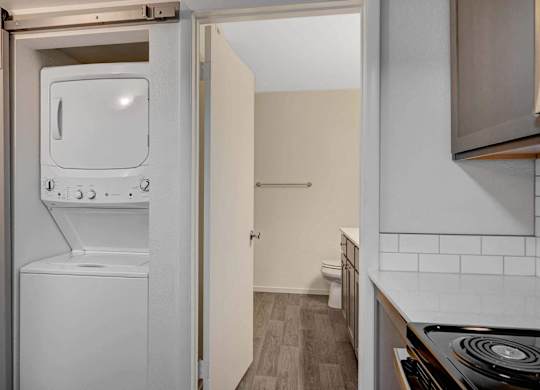 A small kitchen with a white fridge and a washing machine.