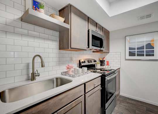 A kitchen with a white sink and black oven.