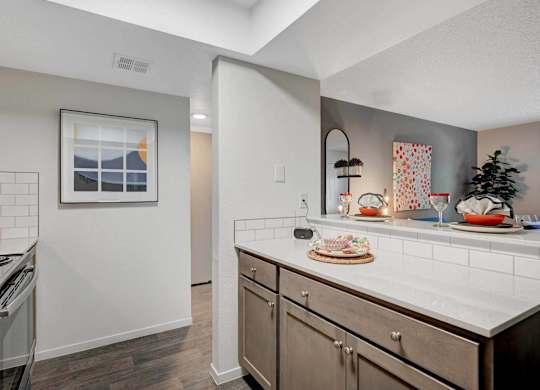 A kitchen with a white counter top and wooden cabinets.