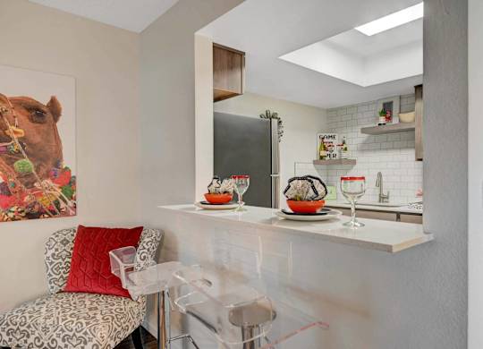 A kitchen with a white counter and a painting of a camel on the wall.
