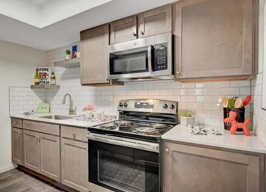 A modern kitchen with a stove, oven, and microwave.