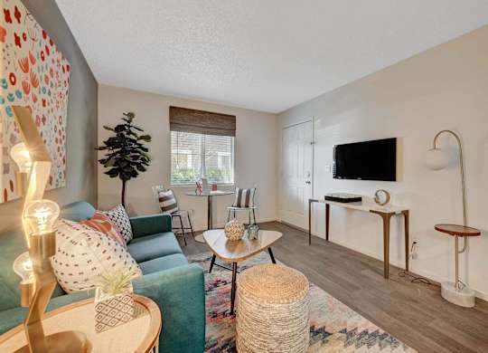 A living room with a green couch and a wooden coffee table.