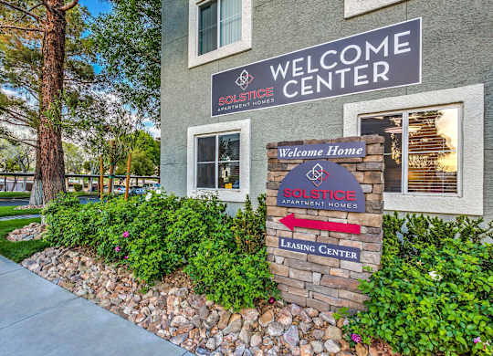 A building with a sign that says "Welcome Center" and "SOLSTICE APARTMENT HOMES".