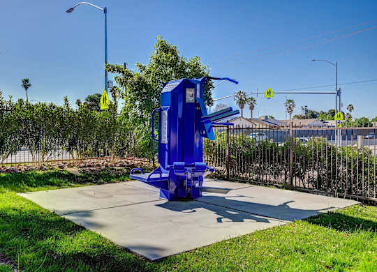 A blue object is placed on a concrete slab in a grassy area.