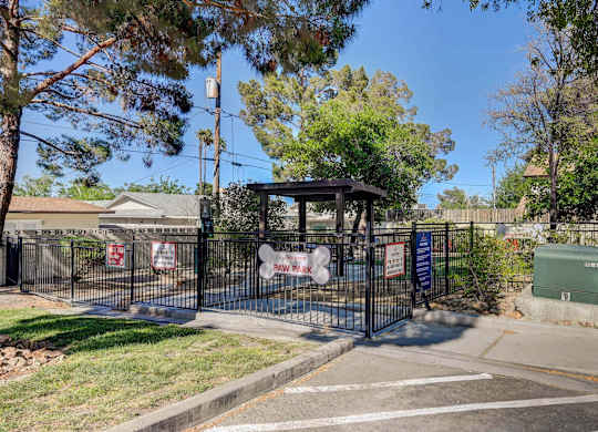 A black gate with a sign that says "No Parking" is in front of a house.
