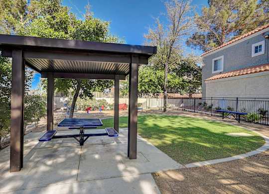 A park with a pavilion and a bench.