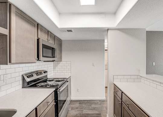 A kitchen with a stove, microwave, and oven. at The 95 Apartments, Las Vegas, NV