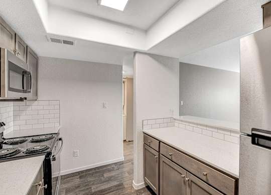 A kitchen with a stove top oven and a refrigerator. at The 95 Apartments, Nevada, 89129