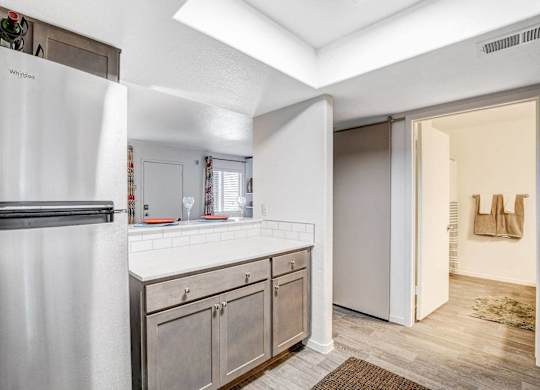 A kitchen with a white refrigerator and wooden cabinets. at The 95 Apartments, Las Vegas, Nevada