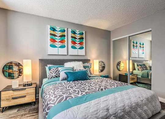 A bedroom with a large bed and a painting above it.