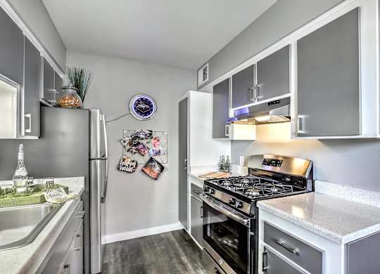 A modern kitchen with a stainless steel refrigerator and a stove top oven.