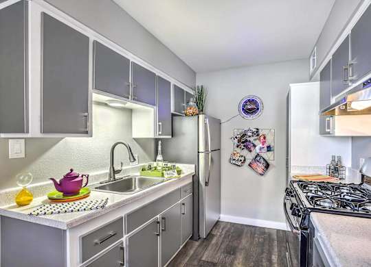 A kitchen with a white fridge and a black stove top.