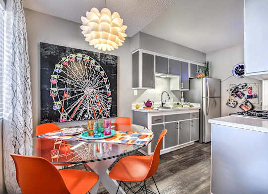 A kitchen with a dining table and chairs.