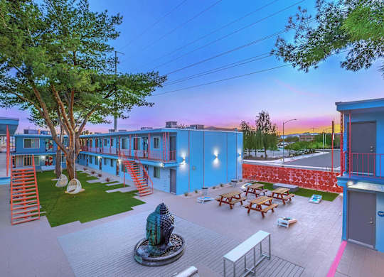 A courtyard with a fountain and picnic tables.