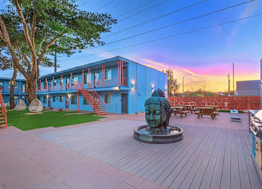 A statue of a face sits in the middle of a courtyard.
