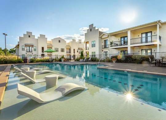 A sunny day at a modern apartment complex with a pool.