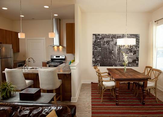 A kitchen with a dining table and chairs.