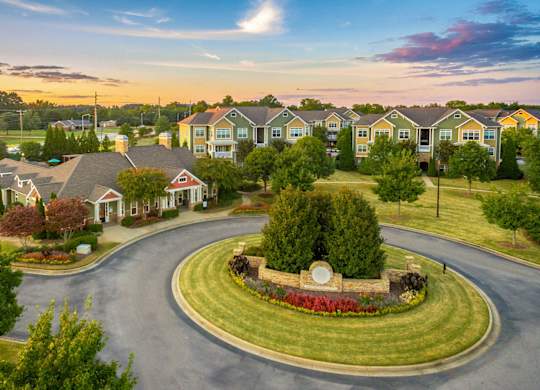 A residential area with houses and a roundabout in the foreground.