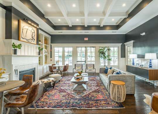 A living room with a fireplace and a rug on the floor.