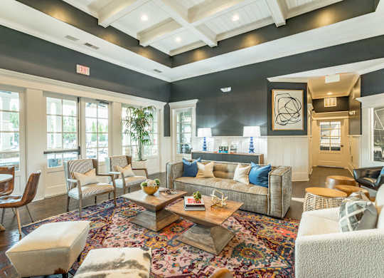 A living room with a large rug and a variety of seating options.