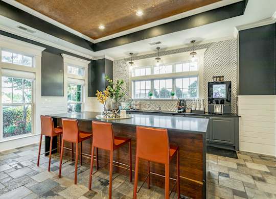 A kitchen with a bar area and chairs.
