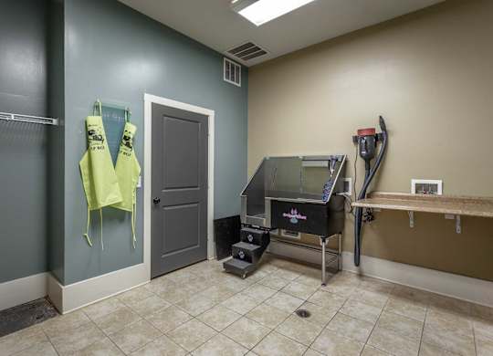 A room with a treadmill and a table.