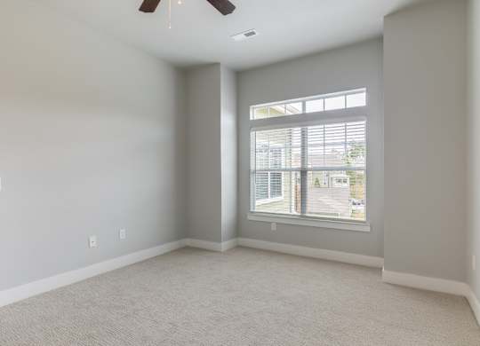 A room with a window and a ceiling fan.