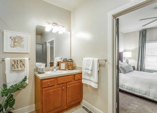 A bathroom with a wooden vanity and a mirror above it.