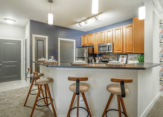 A kitchen with a bar area featuring a counter and stools.