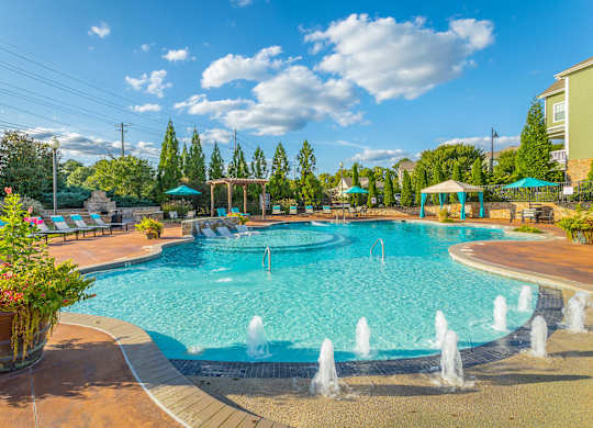 A large swimming pool with a fountain in the middle of it.