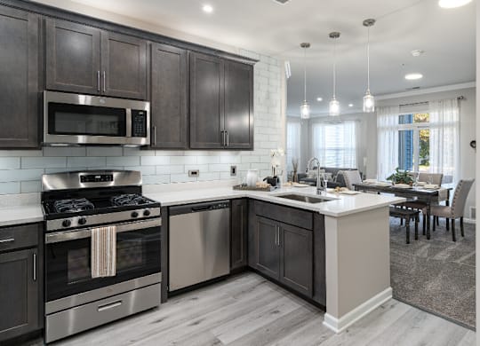 a kitchen with stainless steel appliances and a large island with a sink at Bristol Station, Naperville, IL