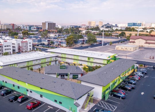 Aerial view of four Las Vegas Fusion apartment buildings in a square around amenities house with Las Vegas skyline in background