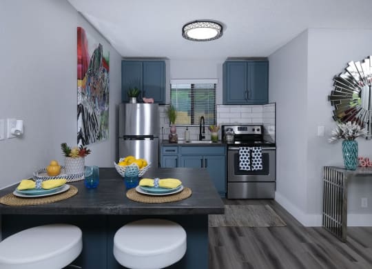 Fusion Las Vegas apartment kitchen with blue and yellow dinette place settings and modern console table with blue vase.