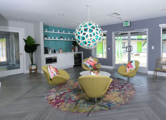 Fusion Las Vegas apartments lobby with modern sitting area and coffee corner with appliances on grey herringbone flooring.