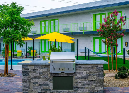 Fusion Las Vegas community barbecue with river rock islands and lush landscape next to community pool and hammocks