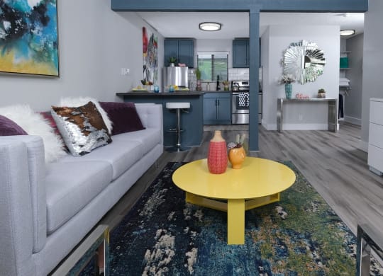 Fusion Las Vegas apartments view from living room to kitchen. Living room has colorful modern decor and kitchen has navy blue accents.