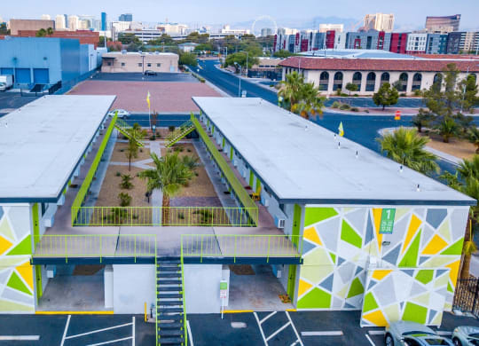 Aerial view of Fusion Las Vegas apartment complex in 89119 with green, yellow, and grey geometric painted walls and lime green railing