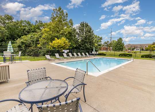 A pool with a table and chairs in front of it.